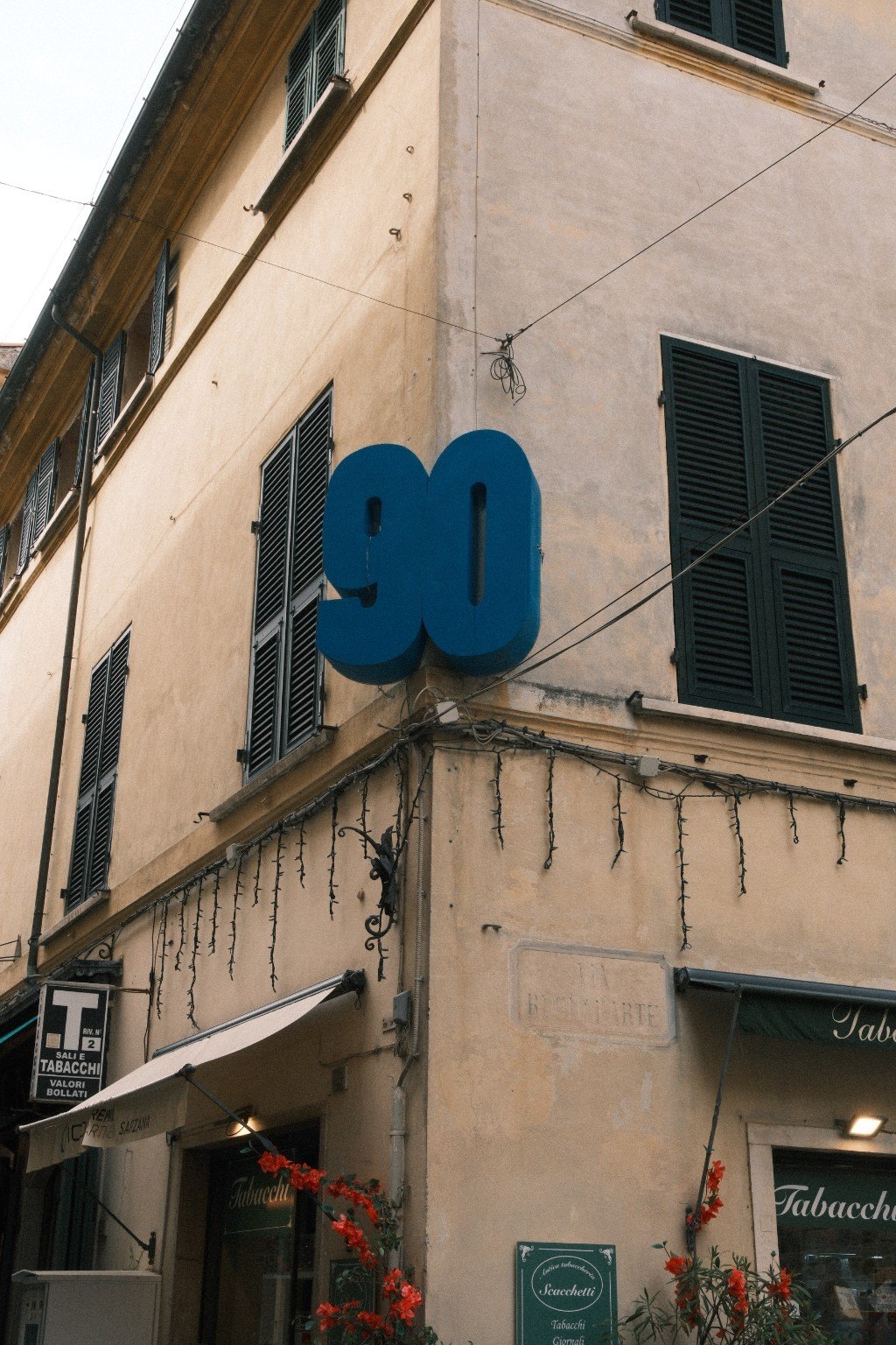 Blaue Zahl 90 an einer alten Hausfassade