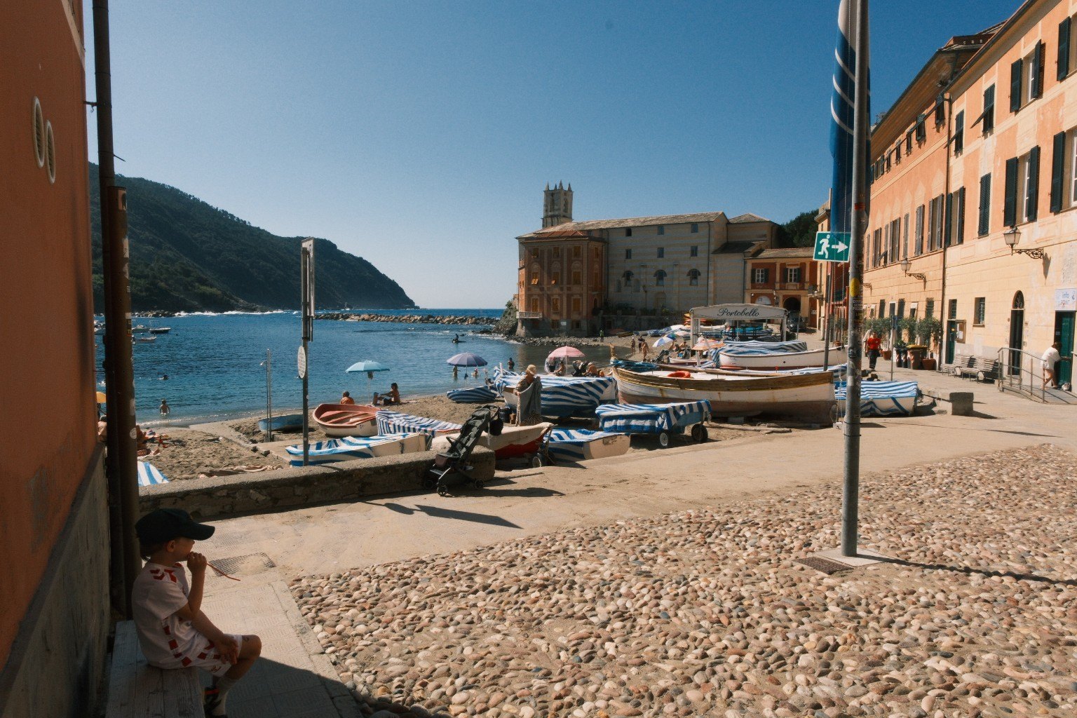Küstenort mit Strand, Booten und Kirche