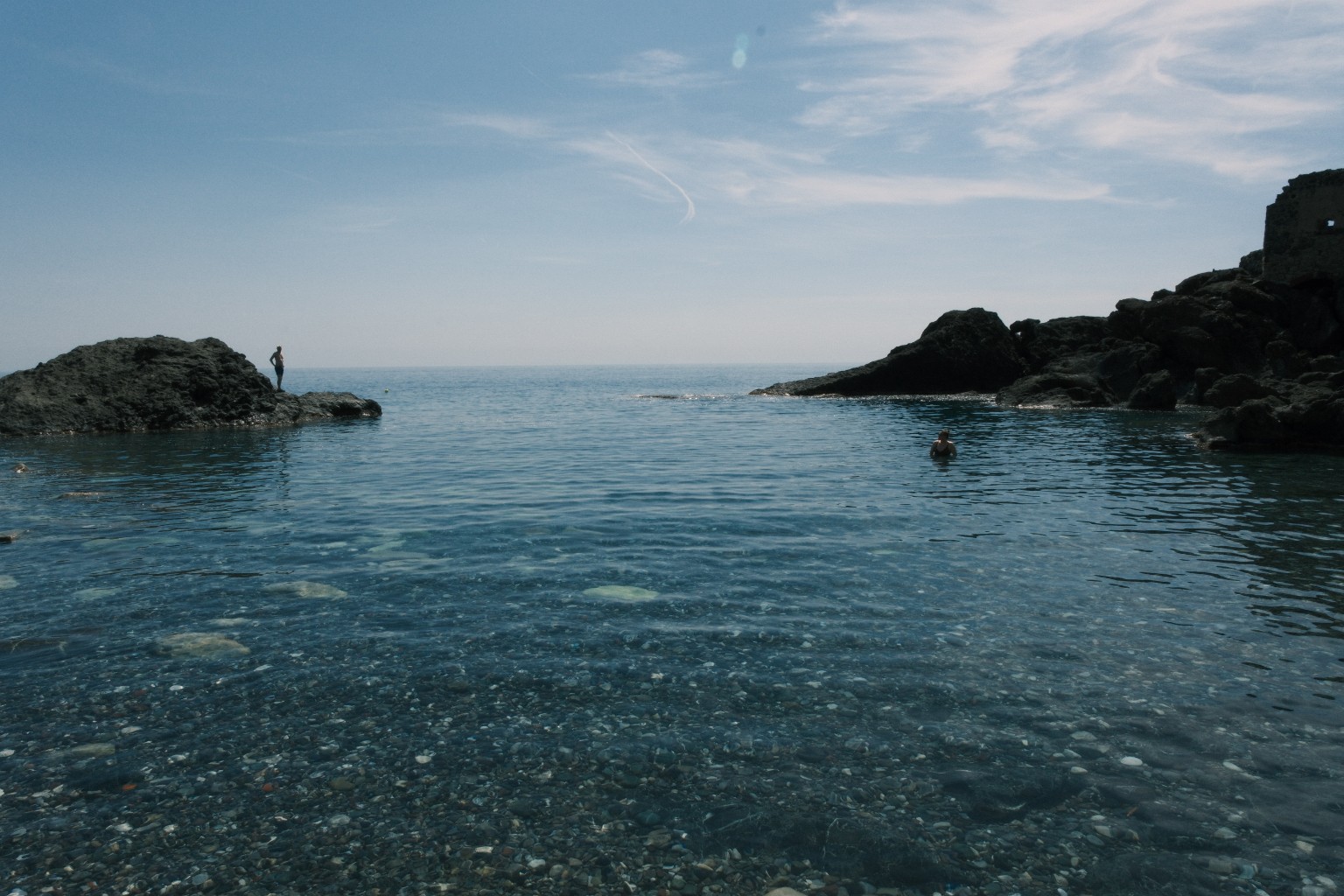 Felsige Bucht in Ligurien mit Meer und Badenden